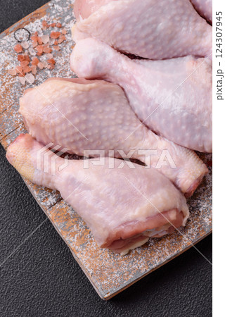Raw chicken legs with salt, spices and herbs 124307945