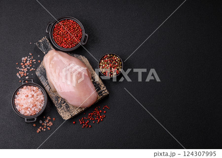 Fresh chicken fillet on a dark concrete table with spices and herbs Fresh chicken fillet on a dark concrete table with spices and herbs 124307995