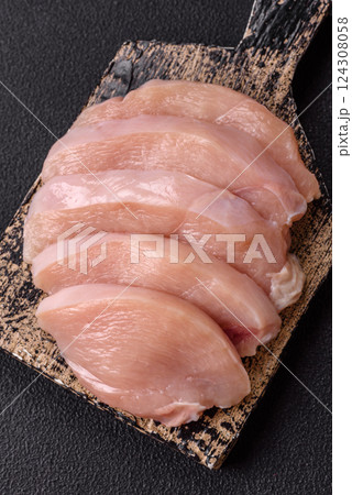 Fresh chicken fillet on a dark concrete table with spices and herbs Fresh chicken fillet on a dark concrete table with spices and herbs 124308058