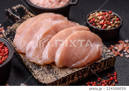 Fresh chicken fillet on a dark concrete table with spices and herbs Fresh chicken fillet on a dark concrete table with spices and herbs 124308059