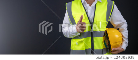 Civil engineer architect standing holding a safety helmet on dark background, Construction site plans to build high-rise buildings, Engineer building concept, Background for with copy space. Civil engineer architect standing holding a safety helmet on dark background, Construction site plans to build high-rise buildings, Engineer building concept, Background for with copy space. 124308939