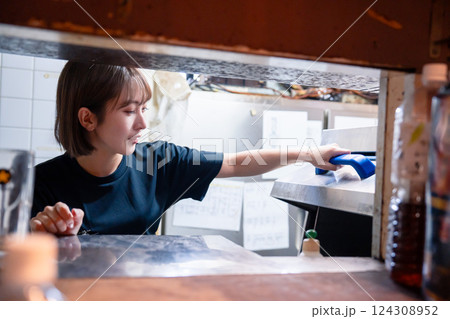 業務用の食洗機でお皿洗いをする飲食店スタッフ 業務用の食洗機でお皿洗いをする飲食店スタッフ 124308952