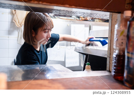 業務用の食洗機でお皿洗いをする飲食店スタッフ 業務用の食洗機でお皿洗いをする飲食店スタッフ 124308955