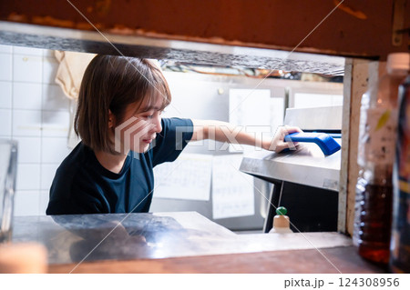 業務用の食洗機でお皿洗いをする飲食店スタッフ 124308956