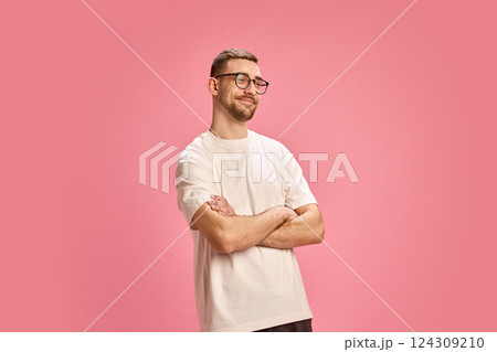 Smiling confident man crossing arms and looking aside in white shirt against pink background. 124309210