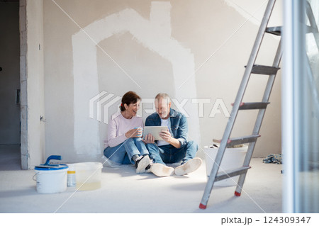 Senior couple renovating their home, browsing for inspirations on tablet. 124309347