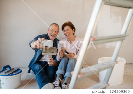 Senior couple taking break during their home renovation, taking a selfie. Senior couple taking break during their home renovation, taking a selfie. 124309369