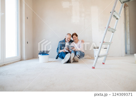 Senior couple renovating their home, browsing for inspirations on tablet. 124309371