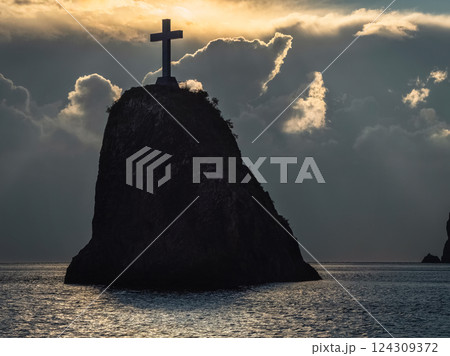 Large cross on a black rock in the sea. Large cross on a black rock in the sea. 124309372