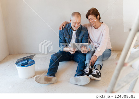 Senior couple renovating their home, browsing for inspirations on tablet. 124309383