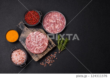 Fresh raw ground beef or pork burger patty with salt and spices Fresh raw ground beef or pork burger patty with salt and spices 124311376