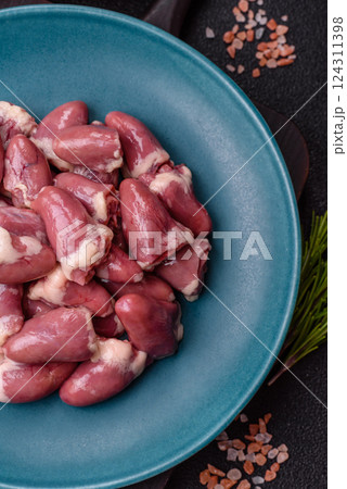 Raw chicken hearts with salt, spices and herbs Raw chicken hearts with salt, spices and herbs 124311398