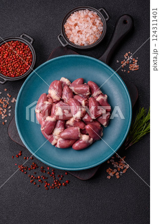 Raw chicken hearts with salt, spices and herbs 124311401