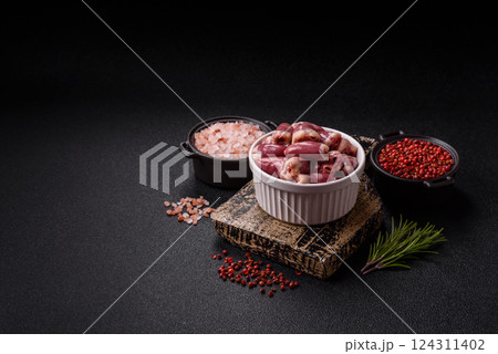 Raw chicken hearts with salt, spices and herbs 124311402