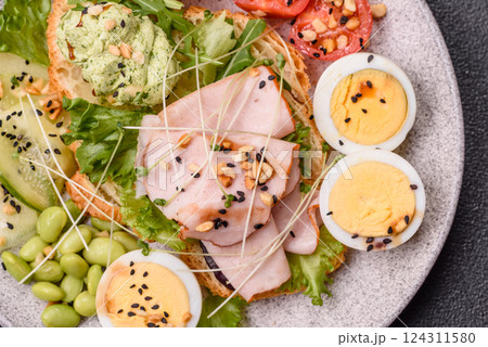 Healthy breakfast consisting of boiled eggs, slices of ham, tomatoes, green beans, aioli sauce 124311580