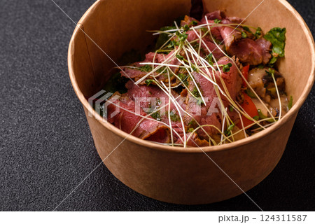 Warm salad consisting of slices of roast beef, greens, tomatoes, cucumbers, green beans 124311587