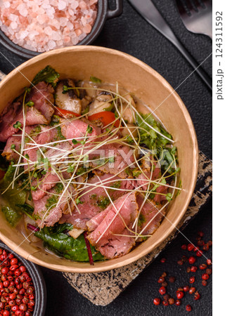 Warm salad consisting of slices of roast beef, greens, tomatoes, cucumbers, green beans 124311592