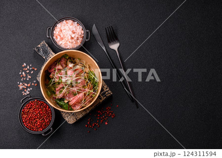 Warm salad consisting of slices of roast beef, greens, tomatoes, cucumbers, green beans 124311594