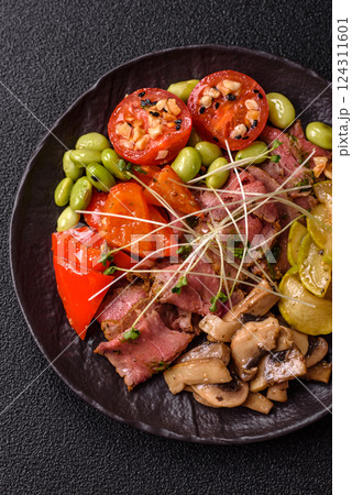 Warm salad consisting of slices of roast beef, greens, tomatoes, cucumbers, green beans Warm salad consisting of slices of roast beef, greens, tomatoes, cucumbers, green beans 124311601