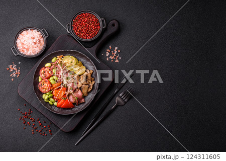 Warm salad consisting of slices of roast beef, greens, tomatoes, cucumbers, green beans 124311605