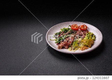 Warm salad consisting of slices of roast beef, greens, tomatoes, cucumbers, green beans 124311607