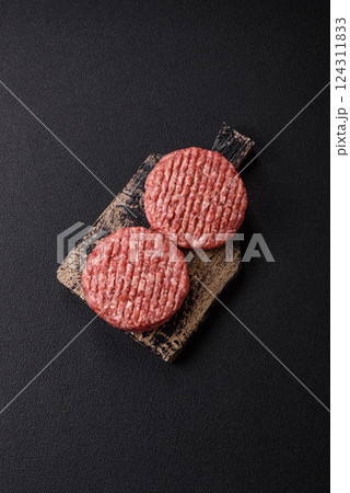 Fresh raw ground beef burger patty with salt and spices Fresh raw ground beef burger patty with salt and spices 124311833