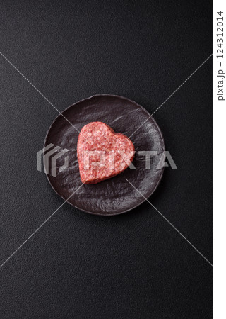 Raw beef or pork burger patty in the shape of a heart Raw beef or pork burger patty in the shape of a heart 124312014
