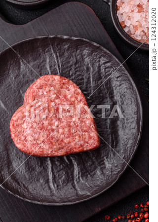 Raw beef or pork burger patty in the shape of a heart Raw beef or pork burger patty in the shape of a heart 124312020