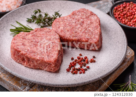 Raw beef or pork burger patty in the shape of a heart 124312030
