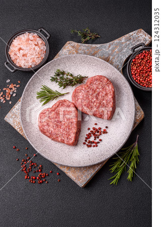 Raw beef or pork burger patty in the shape of a heart 124312035