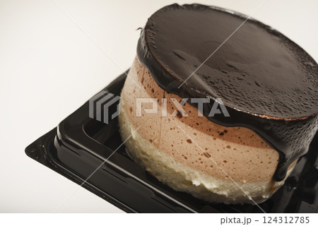 Coffee and milk cheesecake. A cake with cheese and chocolate on a plate. Coffee and milk cheesecake. A cake with cheese and chocolate on a plate. 124312785