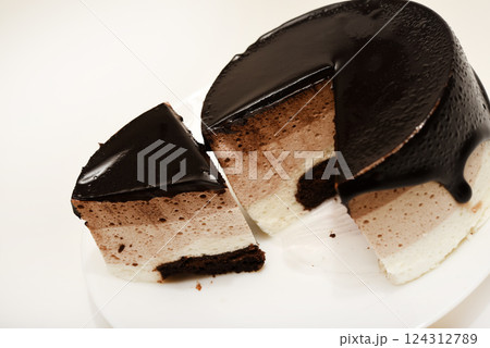 Coffee and milk cheesecake. A cake with cheese and chocolate on a plate. Coffee and milk cheesecake. A cake with cheese and chocolate on a plate. 124312789
