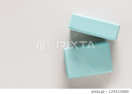 Green yoga blocks on gray background. Yoga practice, relaxation and meditation concept. Top view with copy space. Green yoga blocks on gray background. Yoga practice, relaxation and meditation concept. Top view with copy space. 124313060
