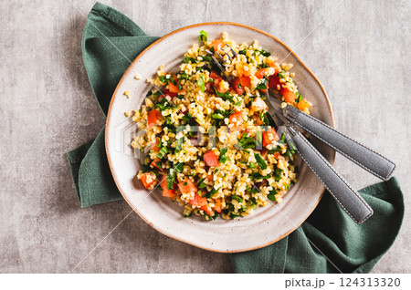 Close up of tabbouleh salad with bulgur, tomato and parsley on a plate on the table top view 124313320