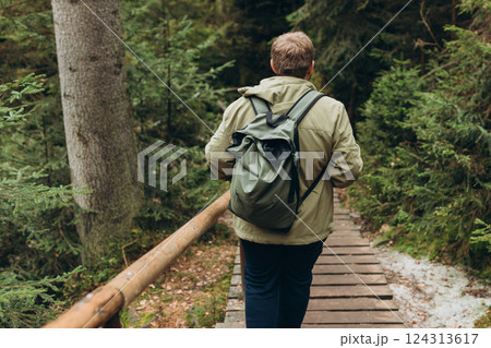 Young 30s man hiking in nature. Travel, adventure. Concept of an active lifestyle. High quality photo. Back view. Fall autumn hiker man outdoor at nature forest Young 30s man hiking in nature. Travel, adventure. Concept of an active lifestyle. High quality photo. Back view. Fall autumn hiker man outdoor at nature forest 124313617