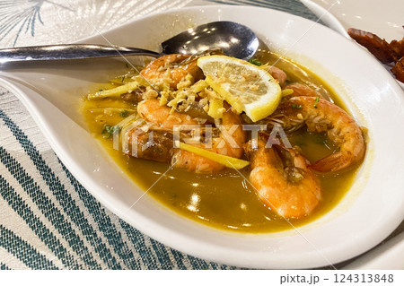 cooked shrimp in butter with lemon on a plate in a cafe 124313848