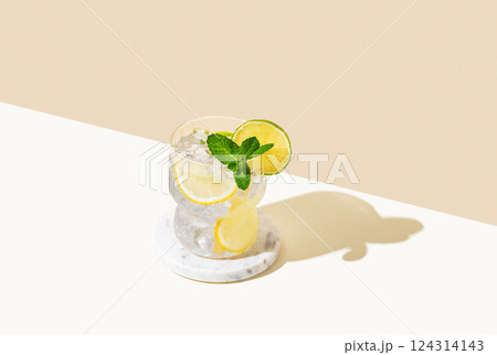 Fresh cocktail mojito with lemon, lime, mint and ice. Citrus lemonade on a white beige background. Fresh cocktail mojito with lemon, lime, mint and ice. Citrus lemonade on a white beige background. 124314143