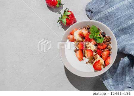 Greek yogurt with homemade chocolate granola, strawberries and banana in a bowl Greek yogurt with homemade chocolate granola, strawberries and banana in a bowl 124314151