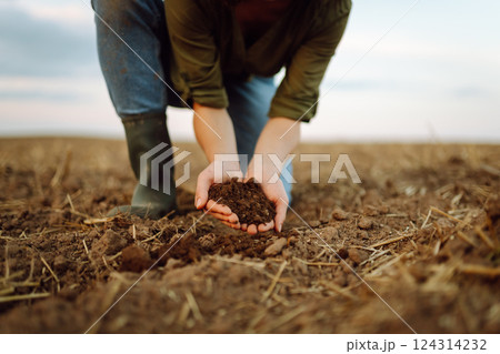 Close-up of a woman farmer's hands holding fresh soil. Agriculture, gardening concept. Close-up of a woman farmer's hands holding fresh soil. Agriculture, gardening concept. 124314232