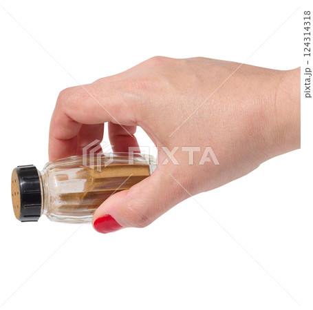 Female hand holding container with ground cinnamon on isolated background 124314318