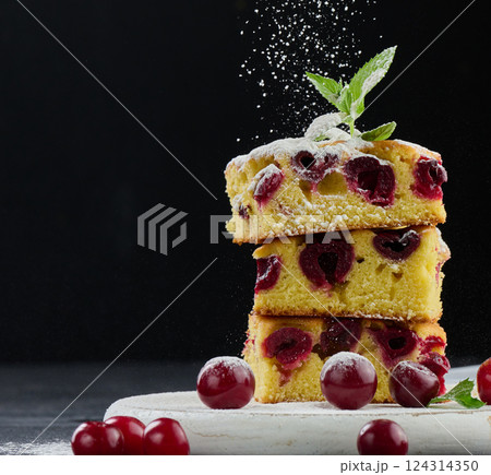 Stack of baked cherry pie sprinkled with powdered sugar on black background 124314350