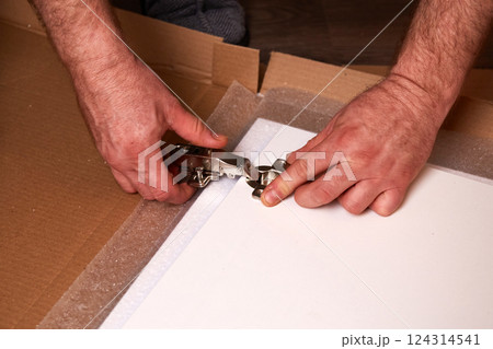 Installing a furniture hinge on the door. Assembling furniture and fixing fittings Installing a furniture hinge on the door. Assembling furniture and fixing fittings 124314541