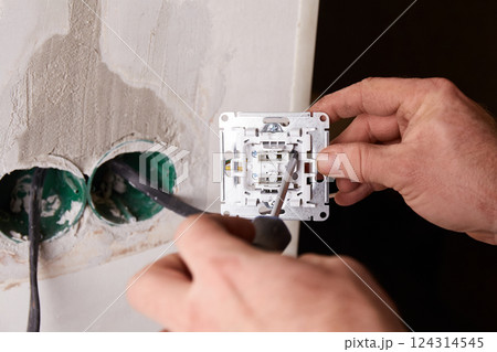 A close-up view of an electrical outlet being installed into a wall.  A close-up view of an electrical outlet being installed into a wall.  124314545