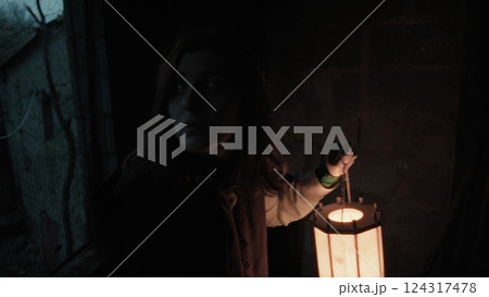Scared Woman Explores A House In The Countryside At Night With A Lantern In Hand 124317478