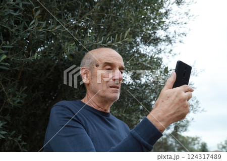 Elderly Man Makes Video Call In His Countryside Outdoors And Talks On The Phone Elderly Man Makes Video Call In His Countryside Outdoors And Talks On The Phone 124317489