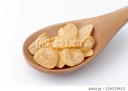 木のスプーンに載せたニンニクチップのクローズアップ 木のスプーンに載せたニンニクチップのクローズアップ 124318423