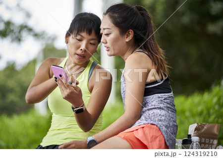 two young asian women female friends relaxing chatting outdoors 124319210