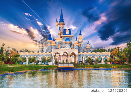 Beautiful fantastic fairy tale castle by the lake at the Magic City amusement Park in Tashkent in Uzbekistan at sunset 124320295