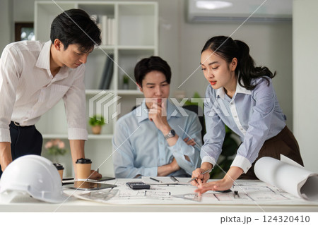 Creative Solutions and Team Collaboration. A diverse team reviews their architectural designs for an innovative project. 124320410