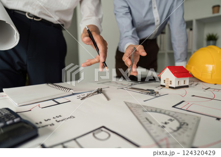 Architectural Planning and Drawing. Close-up of a team discussing blueprints and designs at a work table. Architectural Planning and Drawing. Close-up of a team discussing blueprints and designs at a work table. 124320429